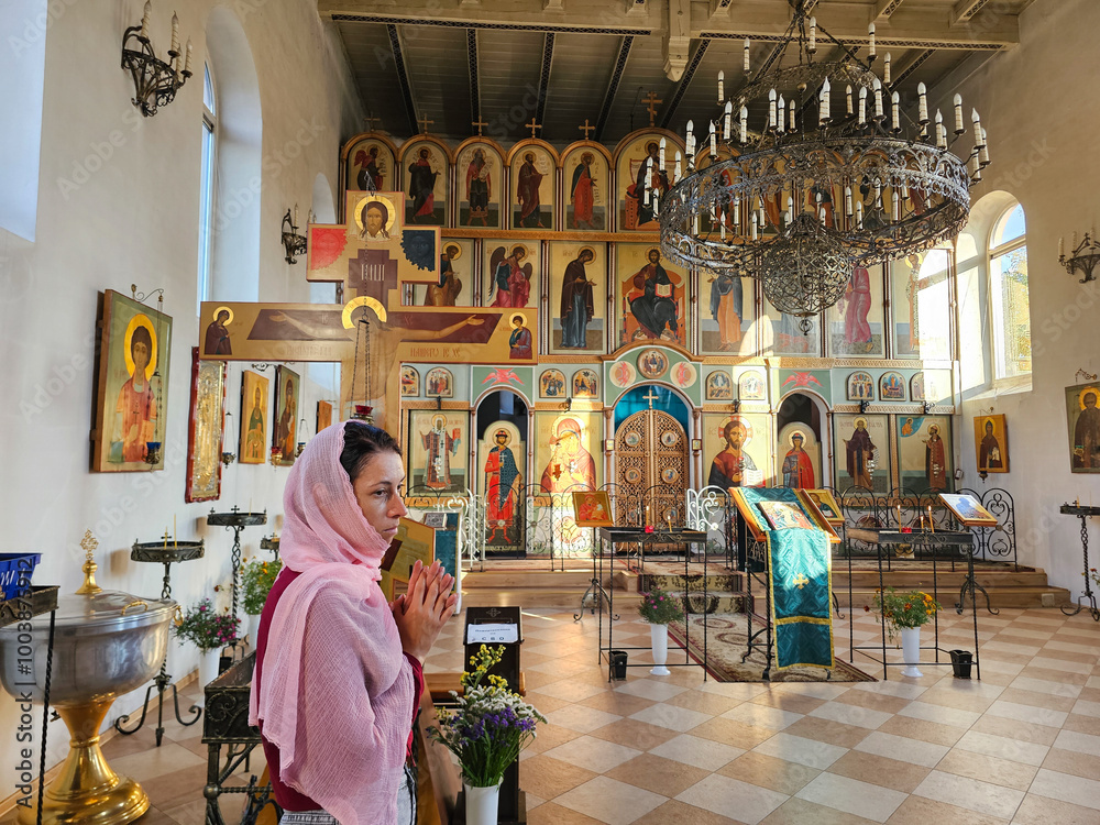 Wall mural woman praying in christian church, icons, candles, faith, god, faith in god, girl crossing herself a