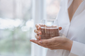Woman holds a glass of water in her hands. Selective focus, Close Up