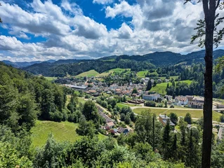 Fototapete Rund A Beautiful Scenic View of a Serene Mountain Village, Enveloped by Lush Greenery and Breathtaking Landscapes © SimonMichael