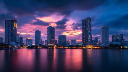 Fototapeta premium Skyline of modern Bangkok, Thailand. Majestic skyscrapers on the waterfront under the cloudy sky at twilight time.