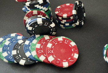 Colorful different value poker chips on black casino table, win after game. Concept of hazard gaming