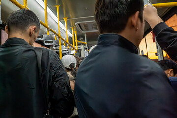 This candid photograph captures a typical day during a subway commute, with a crowd of passengers...