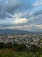 Obraz premium Dramatic cityscape panorama overlooking green hills