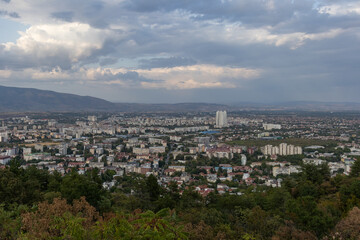 Naklejka premium Dramatic cityscape panorama overlooking green hills