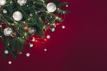 Christmas background with Christmas tree toys, fir branches, stars and lights. Red background.