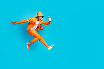 Photo of crazy carefree guy jumping look empty space wear stylish trendy outfit isolated cyan color background