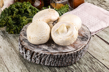 White champignon mushrooms heap over board