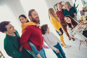 Obraz premium Photo of friendly sweet family play spend time together have fun piggyback eating holiday dinner smiling hugging indoors house room