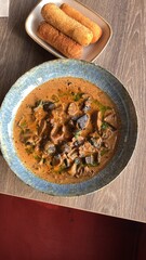 close up view of food served in restaurant on wooden table, mushroom goulash or ragout with fried croquette, czech food