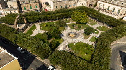 Aerial view of the Manduria municipal villa in the province of Taranto, Italy. In the public park there is a fountain and a war memorial.