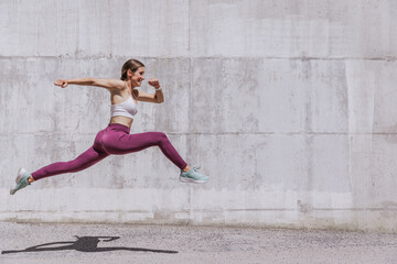 Fit woman in active wear exercising outdoors. Healthy young sportswoman doing fitness. An athlete...