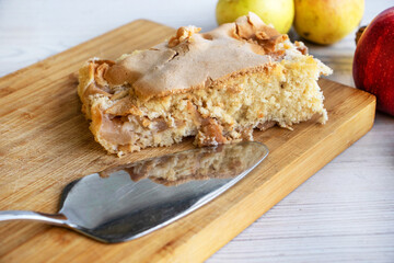 Piece of traditional thanksgiving apple cinnamon pie on the wooden cutting board on the white...