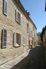 Naklejka premium Narrow Street with Stone Houses and Closed Shutters in a Small French Village on a Sunny Day