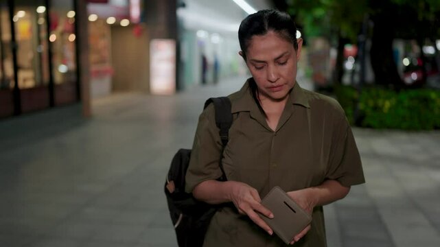 Frustration and worry: a woman confronts an empty wallet under the glow of city lights, highlighting the struggles of financial insecurity.