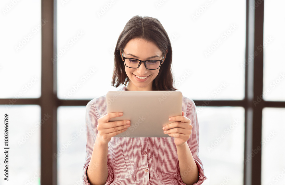 Aufkleber business app. young woman in glasses using tablet and laptop computer in office. free space for text