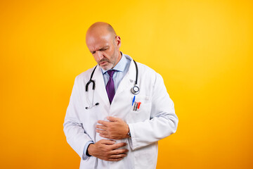 A doctor with his hands on his stomach and appears to be in pain.