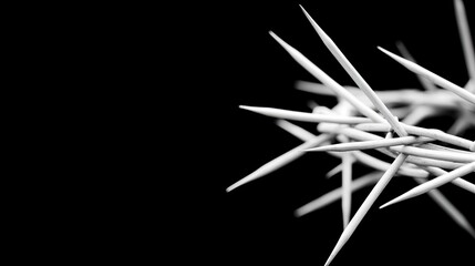 Fototapeta premium A crown of thorns, formed from sharp metal, lies with angled nails beneath a ray of light in a dark room, evoking feelings of drama and suffering in this intimate perspective