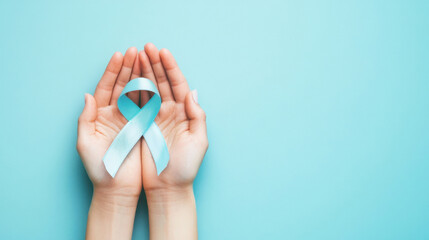 Close-up of hands holding a blue ribbon on a light blue background, symbolizing support and awareness for world diabetes day.
