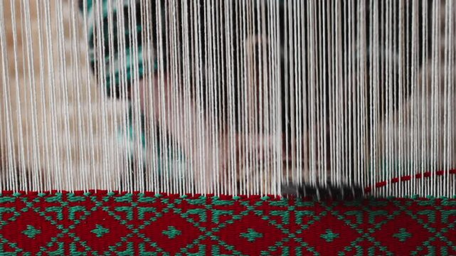 Hand loom, ancient carpets production technique. Working on a handloom, a man using a handloom to create for traditional Persian carpet in Iran village. High quality Super Slow Motion 4K video