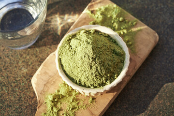 Green barley grass powder in a white bowl