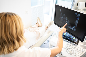 female gynecologist doctor during patients examination with a sonography machine