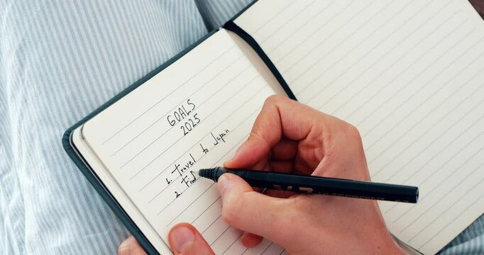 New Year Goals 2025. Woman's Hand Writing in Notebook Goals List. Concept of New Year Planning.