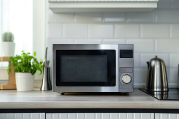 Fototapeta premium Modern stainless steel microwave oven is standing on a countertop in a recently renovated kitchen