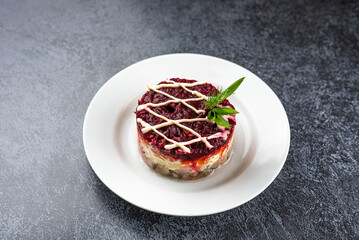 salad fur coat on a white plate on a gray background