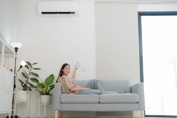 Young woman enjoying air conditioning at home