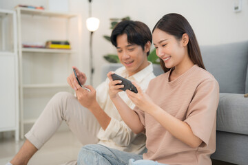 Young couple enjoying smartphone entertainment at home