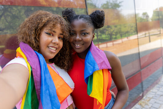 African American and Latin American LGBTQIA+ girls embracing in a park