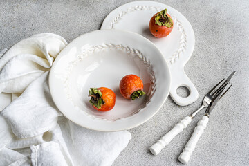 Elegant autumnal table setting with persimmons theme