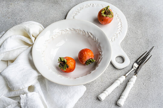 Elegant autumnal table setting with persimmons theme