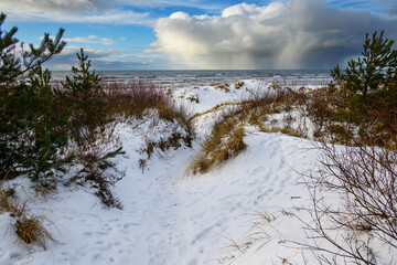 Snow cloud above icy Baltic sea.