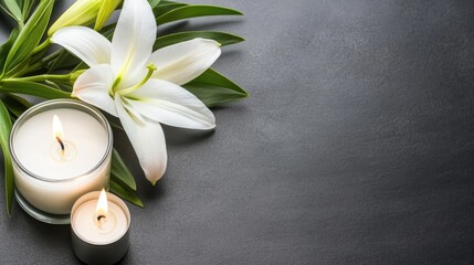 A serene white lily alongside a flickering candle on a polished black background creates a tranquil atmosphere suitable for memorials or moments of remembrance