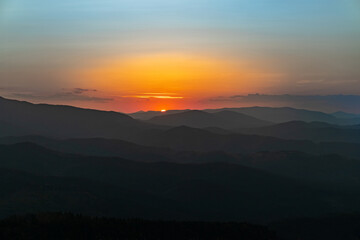 Sunset on the top of the mountain, mountain peaks on the background of the mountain landscape.