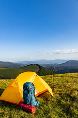 Hiking in the summer with a yellow tent in the mountains. © Bondariev Volodymyr.