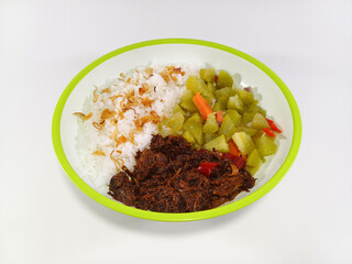 Minced black pepper beef, stir-fried chayote mixed with chopped carrots, served with steamed rice topped with crispy fried shallots, on a plate with green accents, against a white background