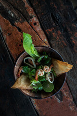 Salad with seafood and shrimps and lettuce on old wooden table. Close Up, Selective focus. Top view, flat lay