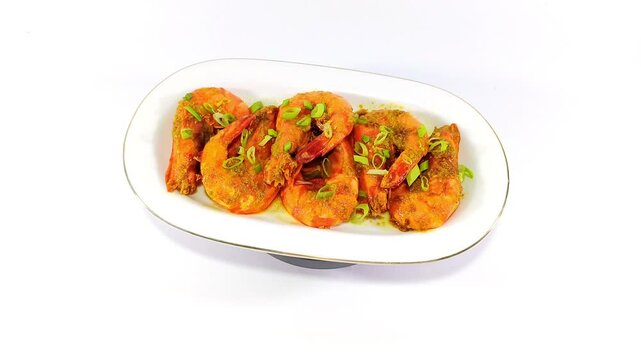 Udang Saus Padang: Indonesian Prawn Dish in Spicy and Sweet Sauce, Garnished with Chopped Spring Onions, Served on a White Plate Against a White Background for a Vibrant and Flavorful Presentation