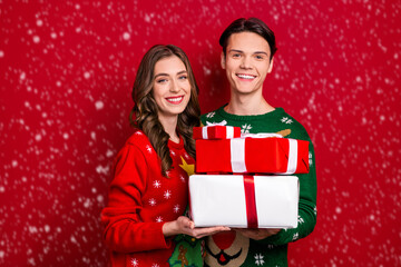 Portrait of two excited positive people hold pile stack festive giftbox isolated on red color background