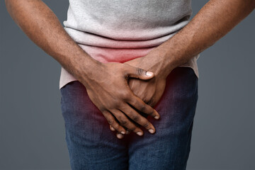 Erectile dysfunction concept. Close up of afro guy holding his crotch. Men's health