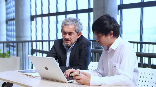Asian senior professor is giving advice to the college student on the research thesis while sitting in the university faculty for education, academic and business