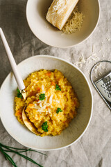 Frisches Kürbis Risotto in einer Schüssel auf einem beigen Leinen Tischtuch. Draufsicht, Herbst.