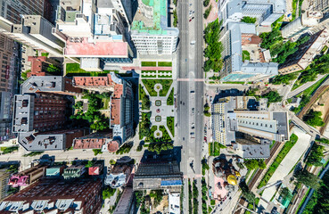 Aerial city view with crossroads and roads, houses, buildings, parks and parking lots, bridges. Helicopter drone shot. Wide Panoramic image.