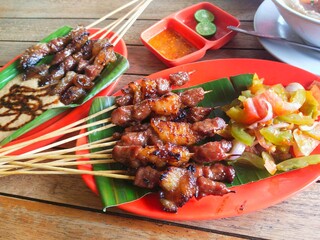 two kinds of goat satay dishes on the table, goat satay with peanut sauce and goat satay with tomato sambal