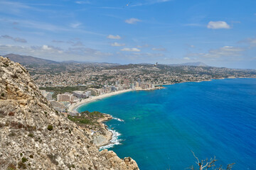 Breathtaking Panoramic View of Calpe's Turquoise Bay from Majestic Cliffside Overlooking Iconic Penon de Ifach Rock Formation. Stunning Costa Blanca Seascape: Calpe's Golden Beaches and Azure Waters
