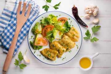 Tempura hake pieces with salad. Top view table with  decoration.