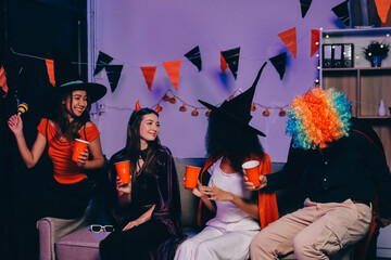 Joyful office Halloween party with coworkers in costumes, celebrating with drinks and laughter, fostering teamwork and festive spirit
