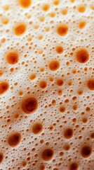 Close-up of frothy beverage texture with bubbles on a creamy surface.